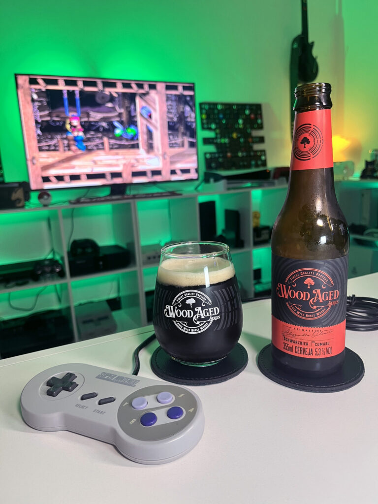 Cerveja Schwarzbier Wood Aged da Caixa da Alegria ao lado de Donkey Kong Country 3