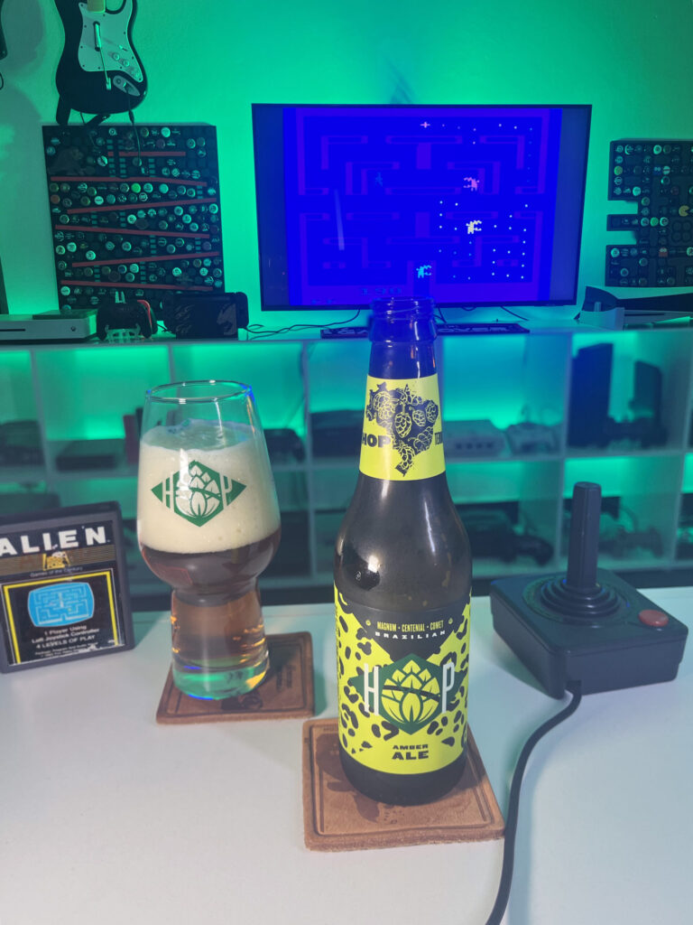 Cerveja Amber Ale âmbar ao lado de Alien no Atari 2600 em clima retrô