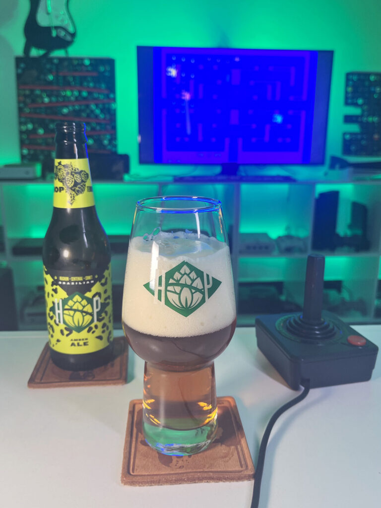 Cerveja Amber Ale âmbar ao lado de Alien no Atari 2600 em clima retrô