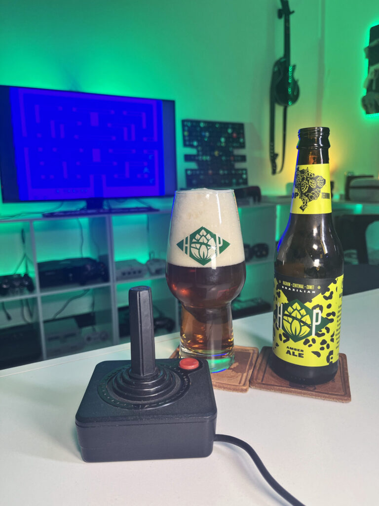 Cerveja Amber Ale âmbar ao lado de Alien no Atari 2600 em clima retrô