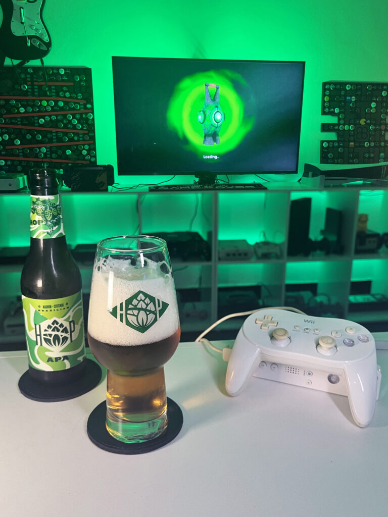 Cerveja APA ao lado de Green Lantern Rise of the Manhunters no Wii em clima de heroi