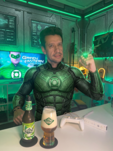 Cerveja APA ao lado de Green Lantern Rise of the Manhunters no Wii em clima de heroi