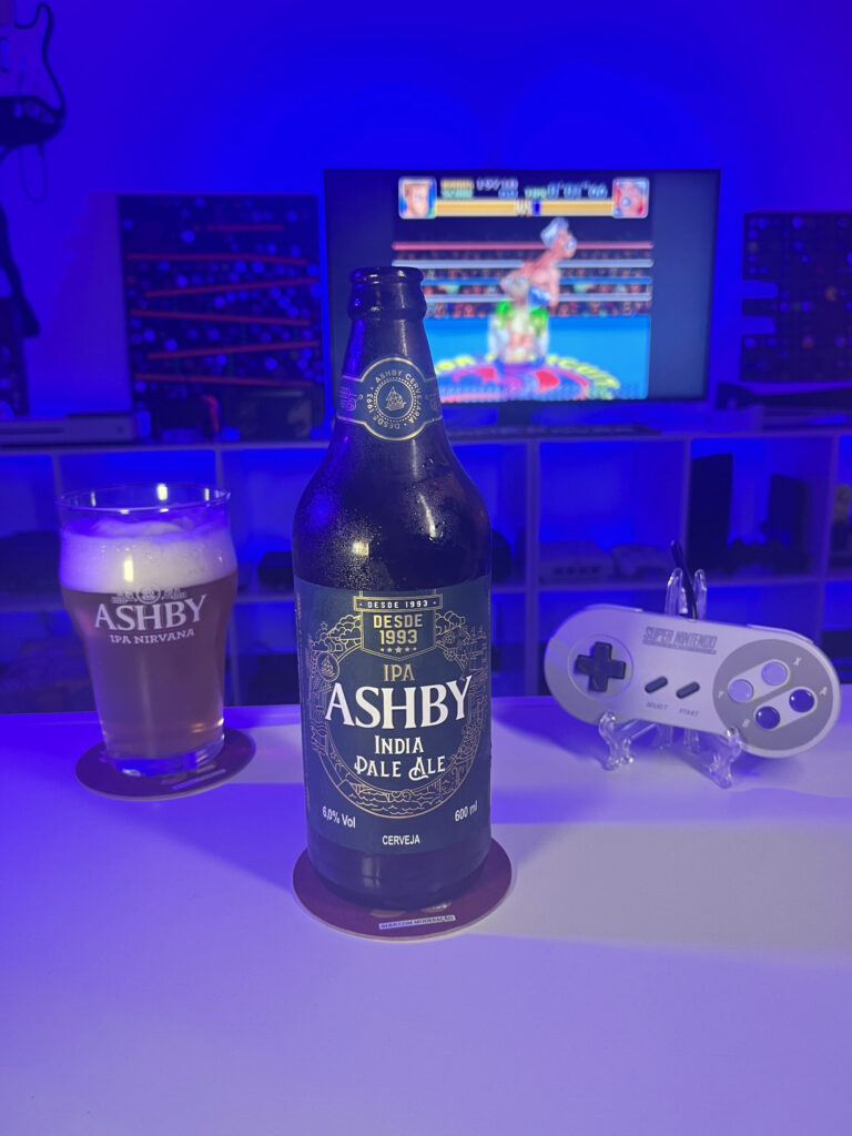Cerveja IPA dourada com espuma branca ao lado de gameplay de Super Punch-Out!! no Super Nintendo em clima retrô.