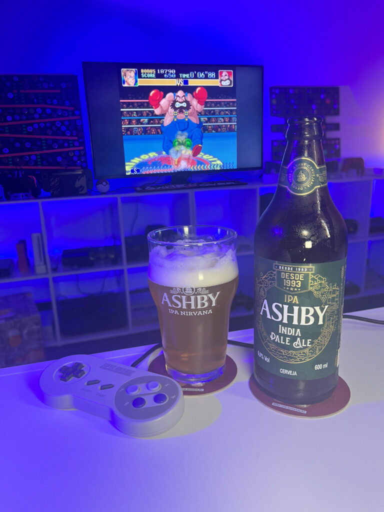 Cerveja IPA dourada com espuma branca ao lado de gameplay de Super Punch-Out!! no Super Nintendo em clima retrô.