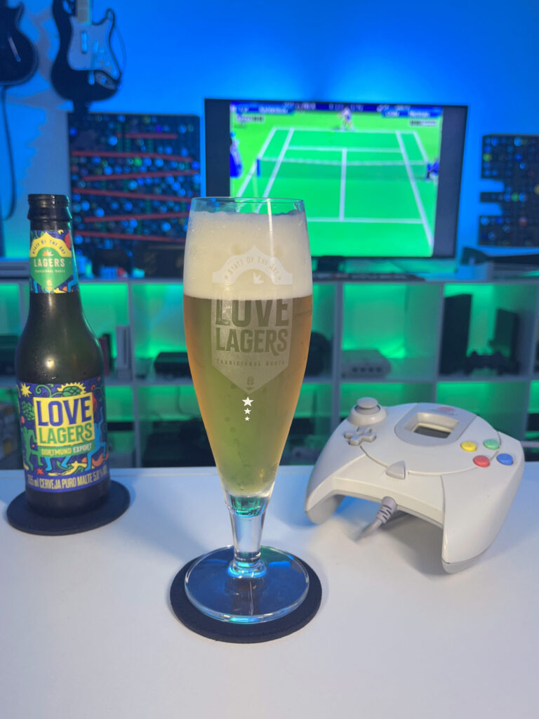 Cerveja dourada translúcida com espuma branca ao lado de gameplay de Virtua Tennis no Dreamcast em clima retrô.