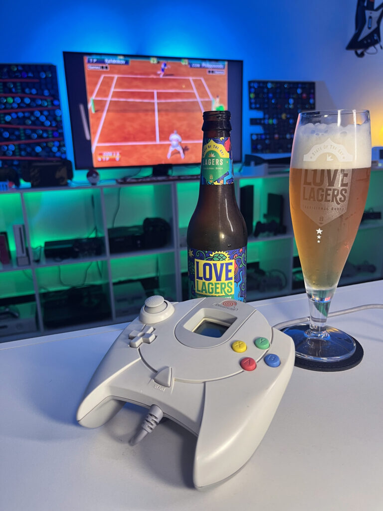 Cerveja dourada translúcida com espuma branca ao lado de gameplay de Virtua Tennis no Dreamcast em clima retrô.