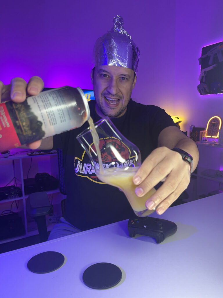 Cerveja NEIPA turva e amarela ao lado de gameplay de Destroy All Humans no Xbox One com clima caótico.