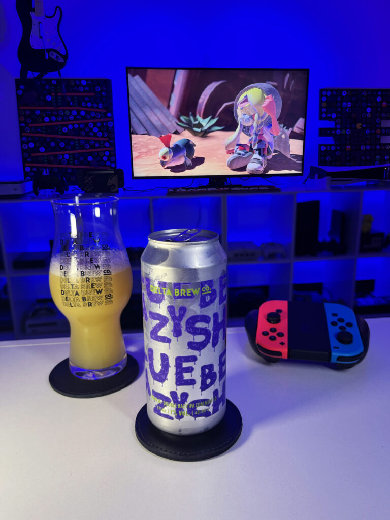Cerveja Double Hazy IPA amarelo palha ao lado de Splatoon 3 no Nintendo Switch em clima de tinta colorida