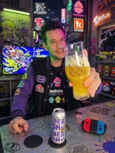 Cerveja Double Hazy IPA amarelo palha ao lado de Splatoon 3 no Nintendo Switch em clima de tinta colorida