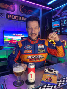 Cerveja Tripel dourada ao lado de Horizon Chase Turbo no PS4 em clima de corrida homenageando Ayrton Senna.