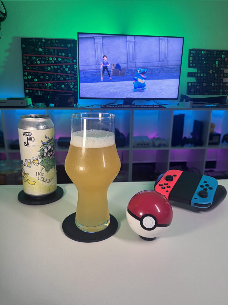 Cerveja Double NEIPA turva e amarela ao lado de gameplay de Pokémon Legends Z-A no Nintendo Switch com clima de exploração.