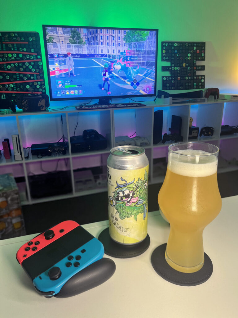 Cerveja Double NEIPA turva e amarela ao lado de gameplay de Pokémon Legends Z-A no Nintendo Switch com clima de exploração.