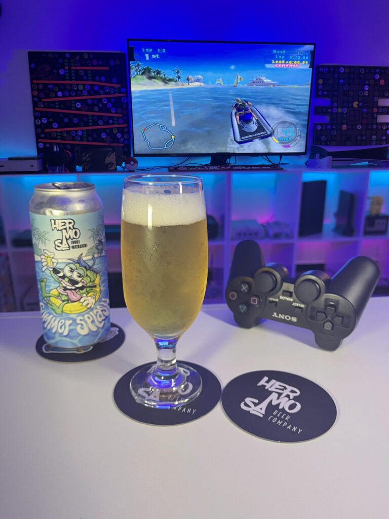 Cerveja New Zealand Pilsner amarelo ouro ao lado de Splashdown no PlayStation 2 em clima de verão.