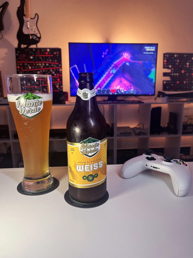 Cerveja Weiss turva amarela ao lado de Minecraft Dungeons no Xbox One em clima de masmorra.