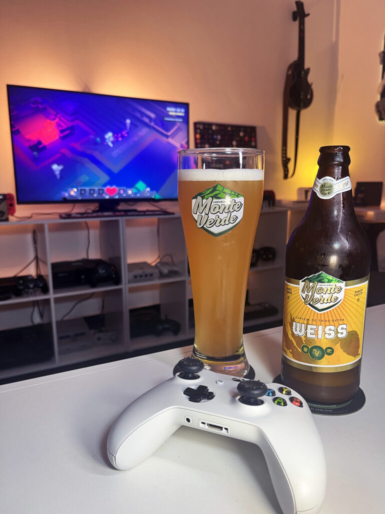 Cerveja Weiss turva amarela ao lado de Minecraft Dungeons no Xbox One em clima de masmorra.