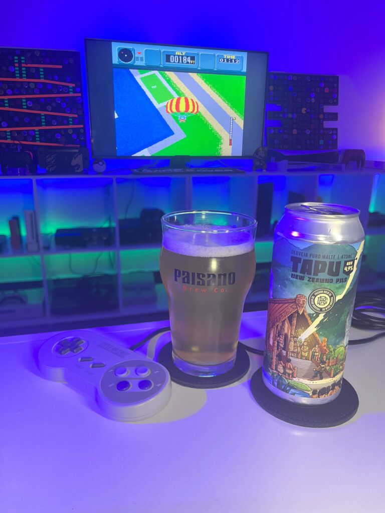 Cerveja clara e translúcida ao lado de gameplay de Pilotwings no Super Nintendo com cenário aéreo retrô.