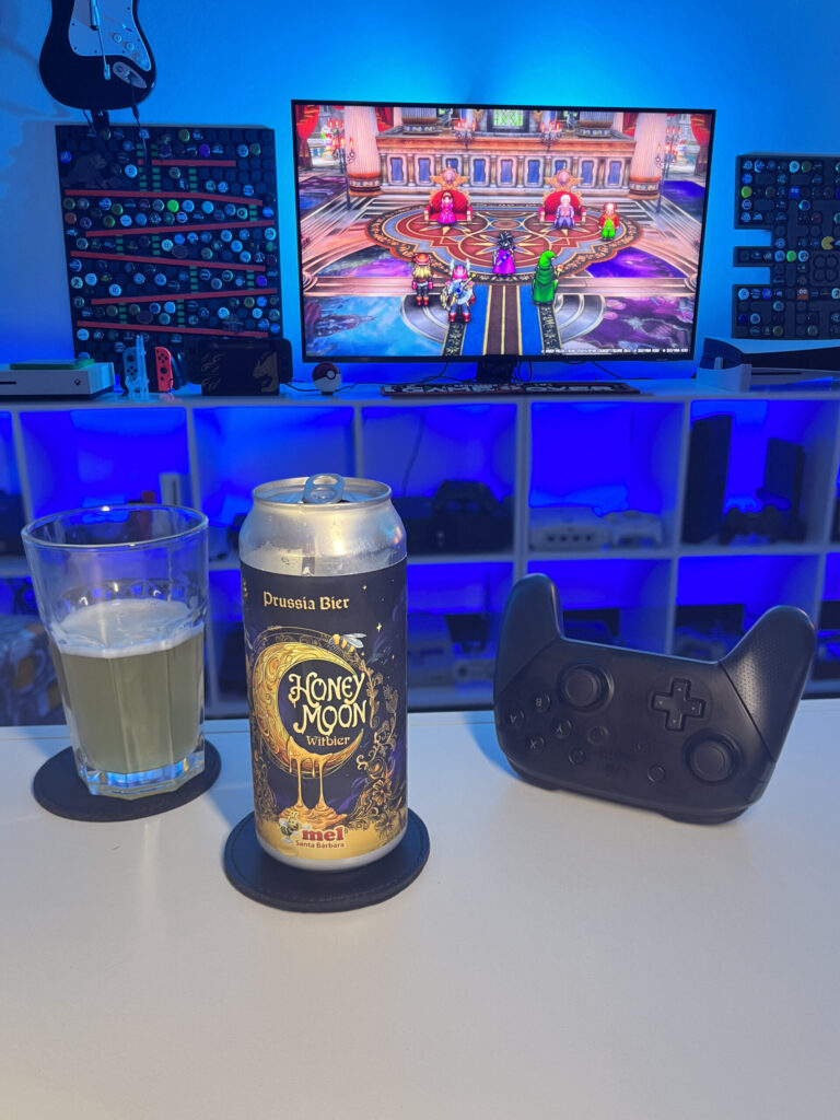Cerveja Witbier clara e levemente turva ao lado de cena de Dragon Quest III HD-2D Remake no Nintendo Switch.