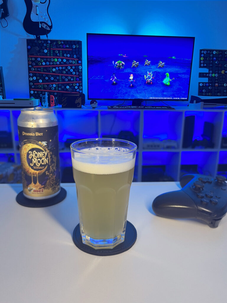 Cerveja Witbier clara e levemente turva ao lado de cena de Dragon Quest III HD-2D Remake no Nintendo Switch.