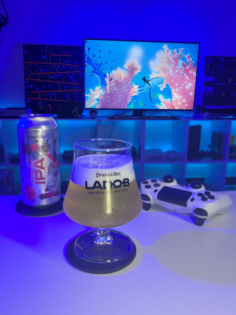 Cerveja clara com espuma branca ao lado de cena subaquática de Abzû no PlayStation 4 em clima contemplativo.