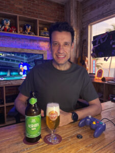 Cerveja American Pilsen com dry hopping dourada e levemente turva ao lado de Sonic Adventure DX no GameCube em clima de alta velocidade.