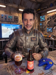 Cerveja Wheat âmbar turva ao lado de Star Wars Episode I Racer no Nintendo 64 em clima de corrida em Tatooine.
