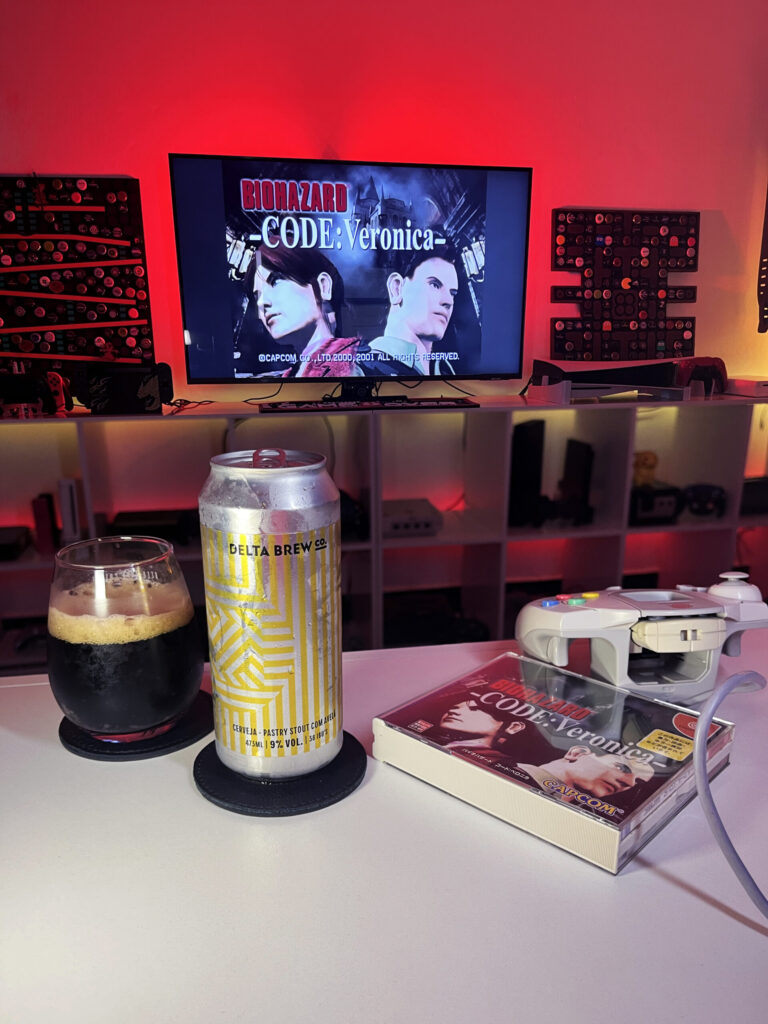 Cerveja Hazelnut Dreams negra com espuma marrom clara, ao lado de Biohazard Code: Veronica no Dreamcast.