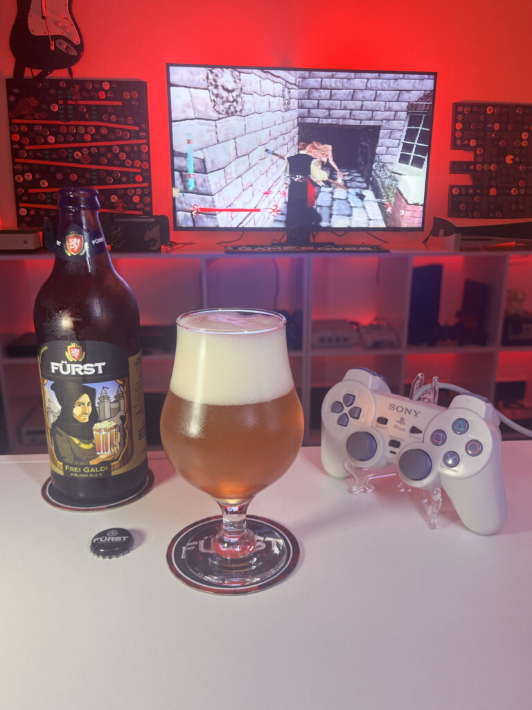 Cerveja Frei Galdi dourado alaranjado com espuma branca, ao lado de Nightmare Creatures no PS1.
