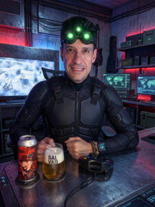 Cerveja American Pale Ale dourada e cristalina ao lado de Splinter Cell Double Agent no Xbox clássico em clima de espionagem.